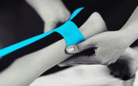 Black,And,White,Image,Of,Kinesiology,Taping,Treatment,With,Blue