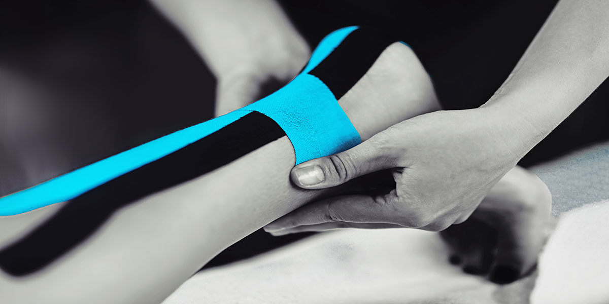 Black,And,White,Image,Of,Kinesiology,Taping,Treatment,With,Blue