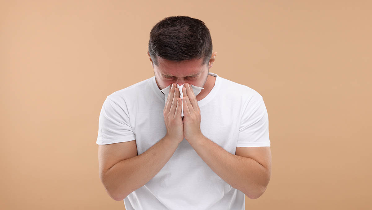 Allergy,Symptom.,Man,Sneezing,On,Light,Brown,Background