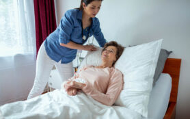 Home,Nurse,Making,Elderly,Patient,Bed.,Female,Caregiver,Adjusting,Pillow