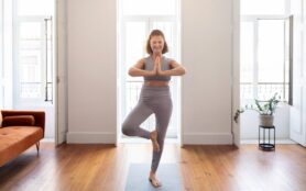 Happy,Senior,Lady,Practicing,Yoga,At,Home,,Standing,In,Tree