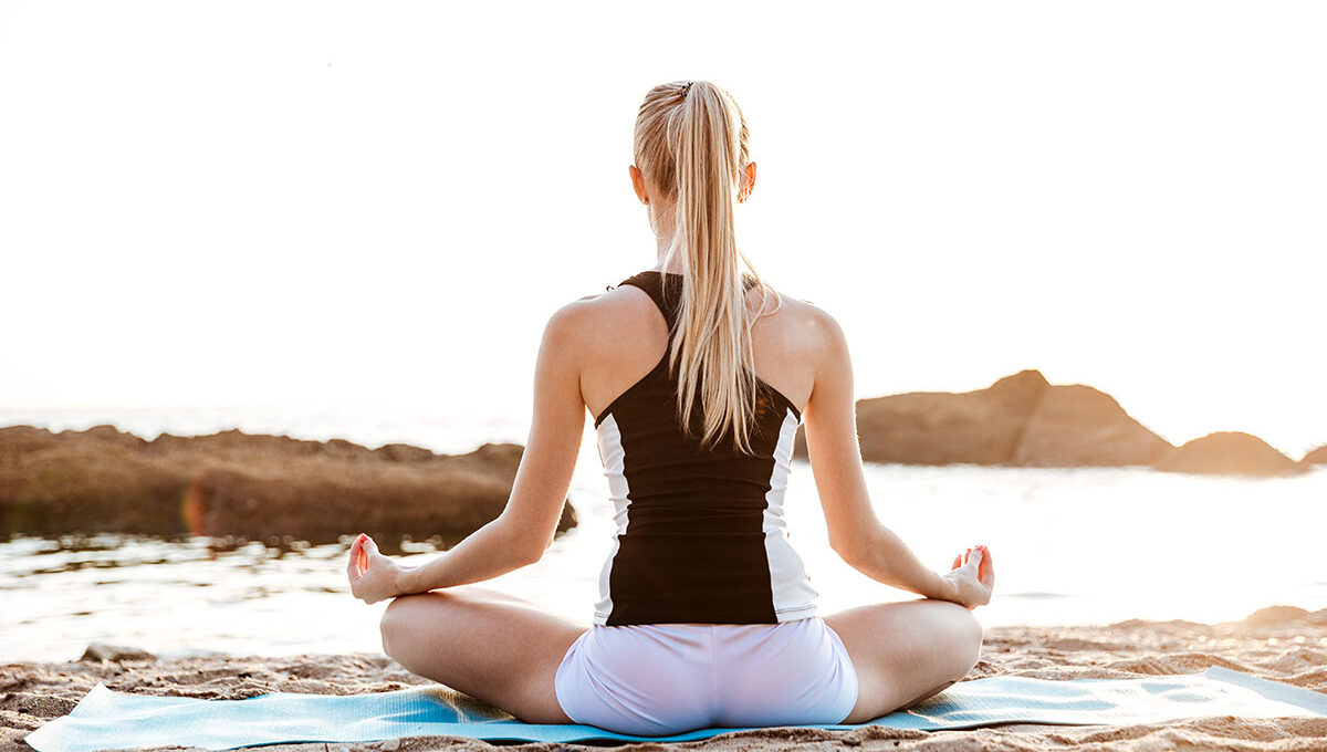 Back,View,Of,A,Young,Woman,Sitting,In,Lotus,Position